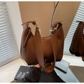 Dettaglio della borsa hobo in pelle marrone con cuciture e fibbia dorata - caffè