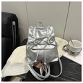 Detailed view of silver metallic mini backpack with ribbon bows on marble surface - Silver