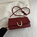 Burgundy woven shoulder bag with golden U-shaped buckle and knot strap detail - Red