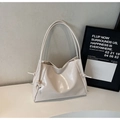 Detail of cream glossy leather tote bag featuring elegant side knot drawstring design - White