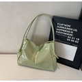 Detail shot of the glossy avocado green patent leather finish and knotted strap design - Green