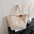 Chic beige canvas tote bag with retro metal rivets and large front pocket detail - White