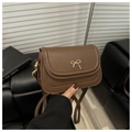 Detailed view of brown leather crossbody bag with elegant golden bow metal buckle - Brown