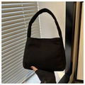 Detailed close-up of solid black corduroy shoulder bag with distinct vertical texture - Black