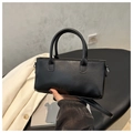 Borsa a mano moderna in pelle nera con scritta fashion su sfondo minimalista raffinato - Nero