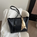 Minimalistische zwarte shopper met wit stiksel en zijden sjaal op een luxe stoel - Zwart