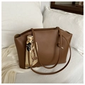 Dettaglio della borsa tote marrone vintage con cuciture bianche e sciarpa di seta floreale - Cuoio