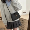 Minimalist black leather crossbody bag with vintage brass buckle and adjustable shoulder strap - Black