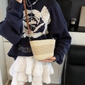 Cream straw bucket bag with brown stripes and leather strap worn by a model - Beige And Khaki