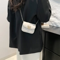 Mini white quilted crossbody bag with gold heart lock and chain strap on black blazer - White