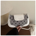 Dettaglio della borsa a tracolla a pois con finiture in pelle e logo con fiocco - Bianco