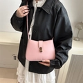 Pink crescent shoulder bag in smooth faux leather with gold buckle worn by model - Pink