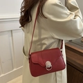 Borsa baguette rossa in ecopelle con patta ondulata e chiusura argento indossata con trench - Rosso