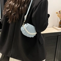 Light blue shell shaped crossbody bag with pearl chain shown on model in black blazer - Blue