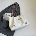 White tote bag with pink straps, 3D bows, and heart accents in a stylish setting - Off-white