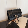 Chic black square crossbody bag with wavy quilting and a gold floral clasp detail - Black