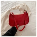 Dettaglio della trama in pelle rossa a motivo coccodrillo di una borsa baguette elegante - Rosso