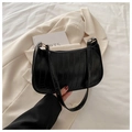 Dettaglio borsa baguette nera in ecopelle con trama coccodrillo e anelli metallici - Nero