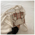 Macro detail of plaid backpack with pink bow embroidery and leather strap accents - White