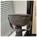Detail of dark grey nylon crossbody bag showing water-resistant texture and zipper - Gray