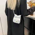 White quilted mini chain bag with large bow and golden lock on a black blazer - White