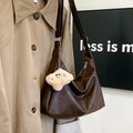 Detalle del bolso tote vintage marrón oscuro con un dije de peluche sonriente - Con Colgante / Marrón