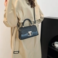 Elegant black handbag with glitter flap and gold ring buckle, shown with model - Black