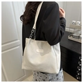 Close-up van de roomwitte kettingtas met zilveren metalen schakels en een getextureerde stof - Rijstwit (Geen Hanger)