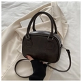 Close-up of black leather Boston bag with embossed logo and silver metal hardware - Black