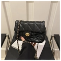 Detail of black quilted leather bag with gold oval twist lock and chain strap - Black