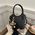 Retro black leather bucket bag with top handle and plush charm on a knit sweater - Black (With Pendant)