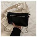 Detail view of black leather crossbody bag with silver studs and chain strap - Black