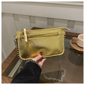 Detalle de bolso bandolera dorado brillante con tachuelas plateadas y correa de cadena - Dorado