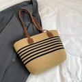 Detail der handgeflochtenen Strohtasche mit schwarzen Streifen und braunen Lederriemen - Khaki