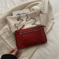Chic red metallic shoulder bag with silver studs and chain strap on beige blazer - Red