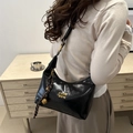 Glossy black leather dumpling bag with gold logo and woven bell charm accent - With Pendant / Black