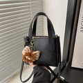 Minimalistische schwarze Leder-Eimertasche mit süßem Plüsch-Anhänger und Handgriffen - Mit Anhänger / Schwarz