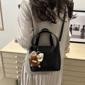 Black litchi grain bucket bag for women with a cute plush charm and crossbody strap - Black (With Pendant)