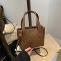 Borsa a secchiello in pelle marrone con grana litchi, manici e tracolla regolabile - Marrone