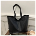 Close-up of black PU leather tote bag with long handles on a stylish glass table - Black