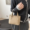 Borsa a secchiello kaki minimalista texture lychee con manici e tracolla indossata dal modello - Kaki