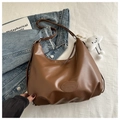 Close-up of brown leather hobo bag with fashion embossed logo and plush cloud charm - No Pendant / Brown