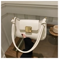Chic beige leather shoulder bag with a gold buckle and knotted strap on a wooden table - White