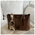 Detail of dark brown leather tote bag with decorative silk scarf on a white sofa - Dark Brown