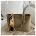 Detail of khaki leather tote bag showing textured finish and decorative silk scarf on strap - Khaki