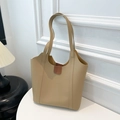 Detalle de bolso tote beige con hebilla de cuero marrón sobre mesa redonda blanca - Caqui