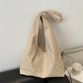 Minimalist large khaki matte tote bag with wide shoulder strap on a black leather sofa - Khaki