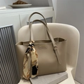 Vintage khaki leather tote bag with baroque scarf and adjustable handles on white chair - Khaki