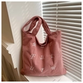 Macro detail of pink corduroy tote bag featuring white embroidery and striped texture - Pink