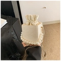 Detail der cremefarbenen Beuteltasche mit floraler Spitze, Perlenkeks und Goldkette - Weiß